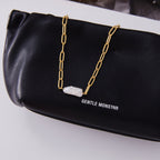 Paperclip necklace displayed with elongated white bead pendant