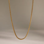 Plain gold tone stainless steel chain hanging in a shallow curve