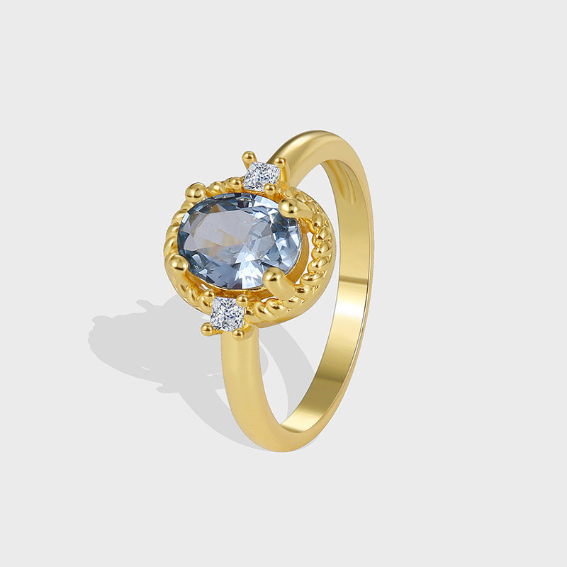 isolated gold plated cocktail ring with blue oval zirconia