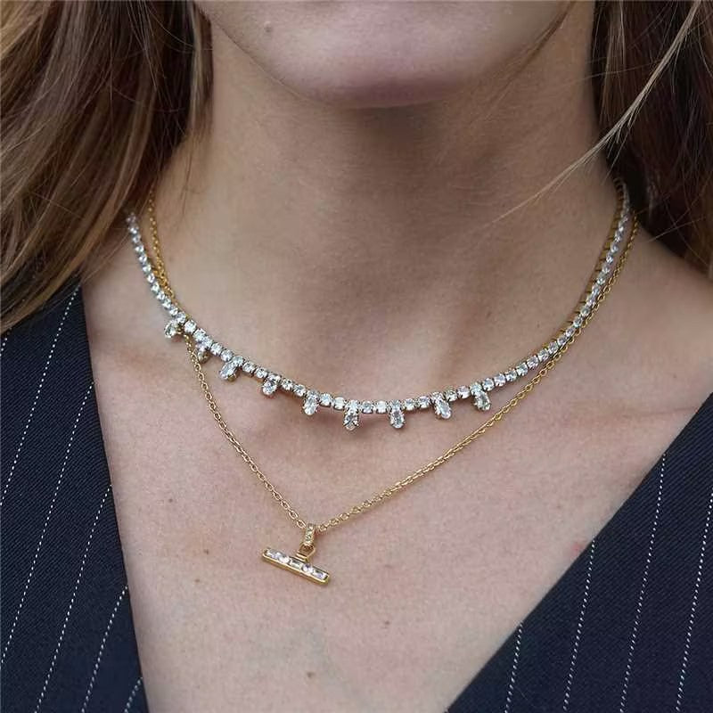 Center-accent T-bar necklace layered below a separate stone necklace