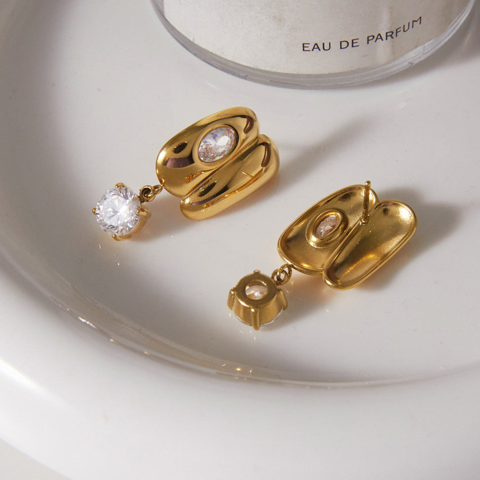 Front and back of sculpted drop earrings on a tray