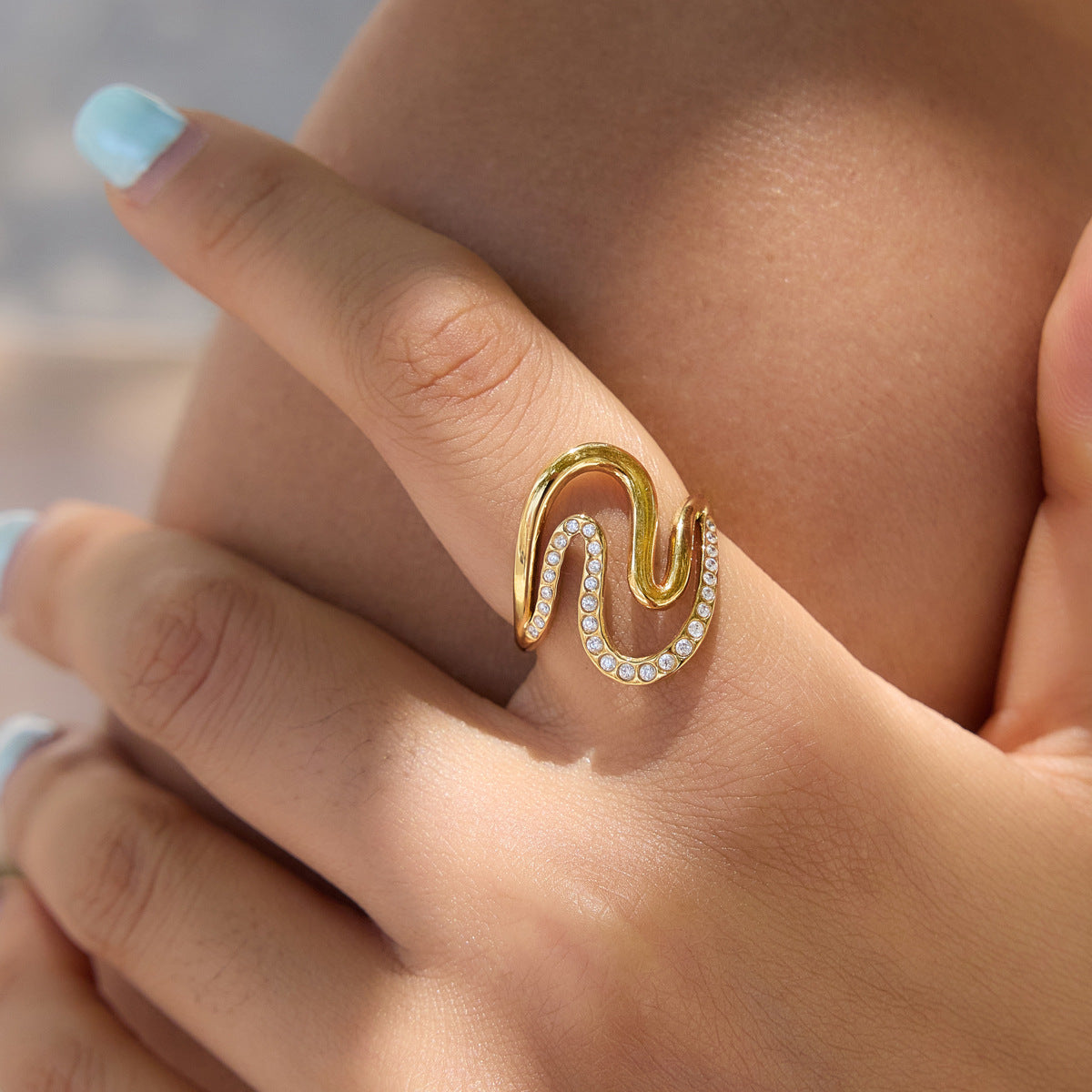 Clear-stone wave ring close-up on finger