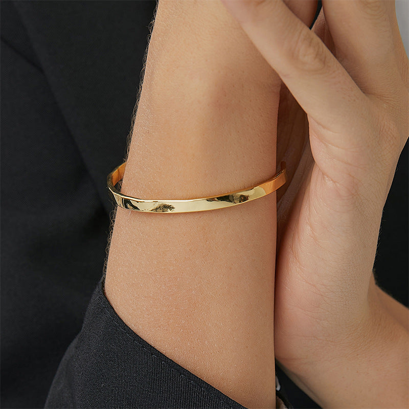 close wrist view of the polished faceted open bangle