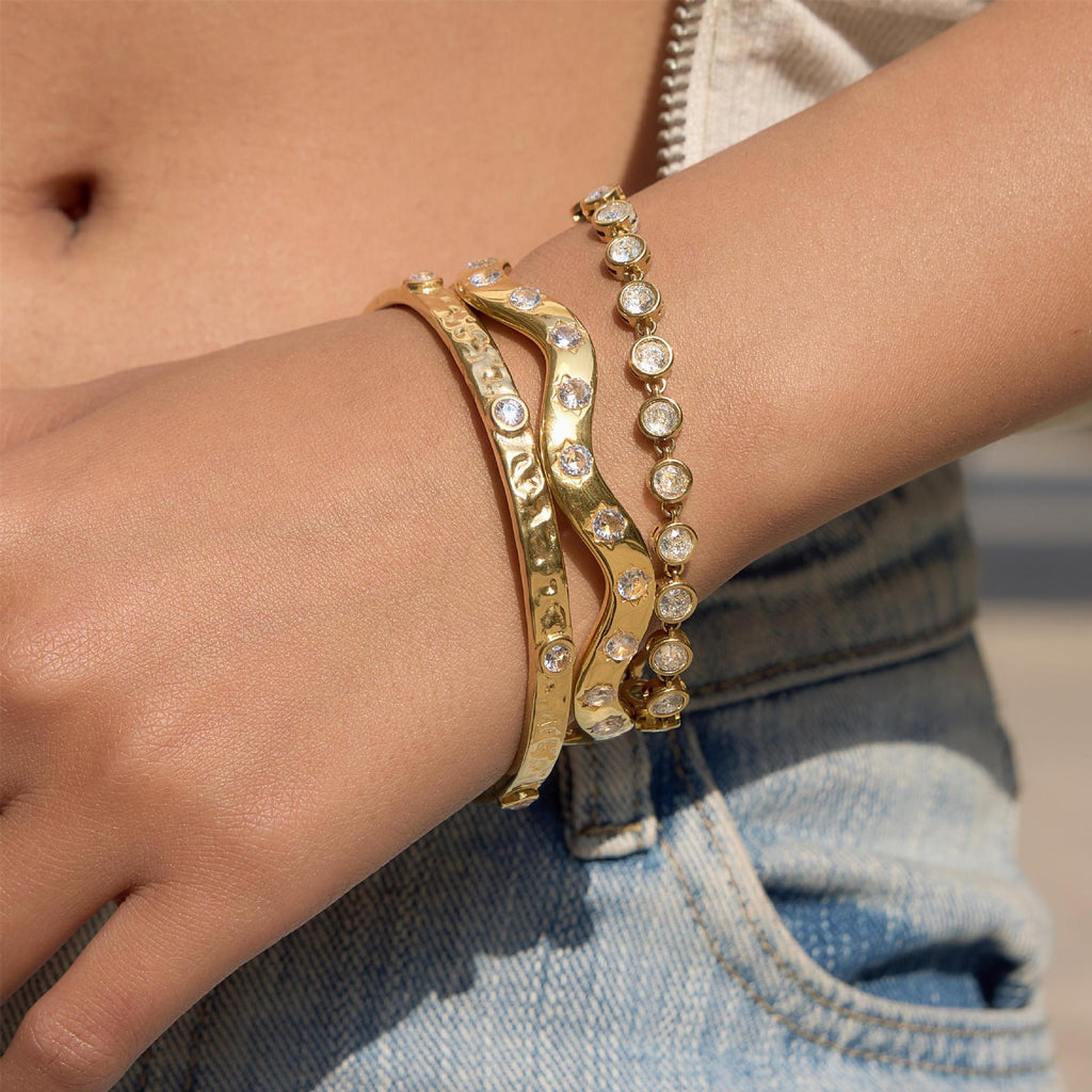 Wavy and hammered bangles worn with stone bracelet