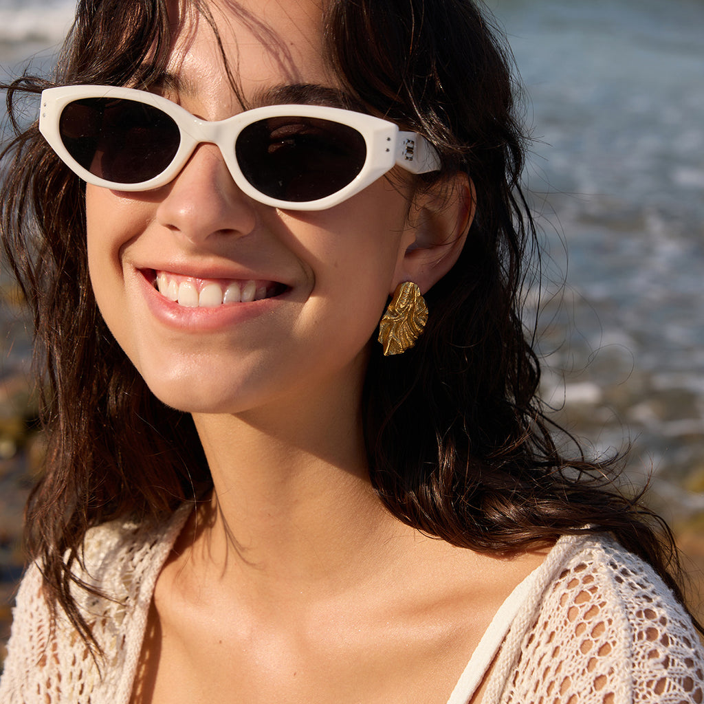Gold-tone textured studs styled with sunglasses