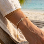 Gold-finish starfish bracelet layered with a plain chain bracelet