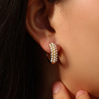 model wearing compact gold plated huggies with white pearl trim