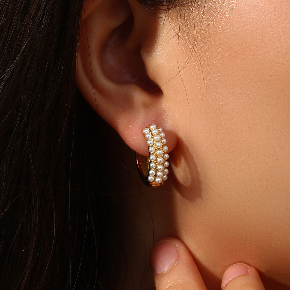 model wearing compact gold plated huggies with white pearl trim