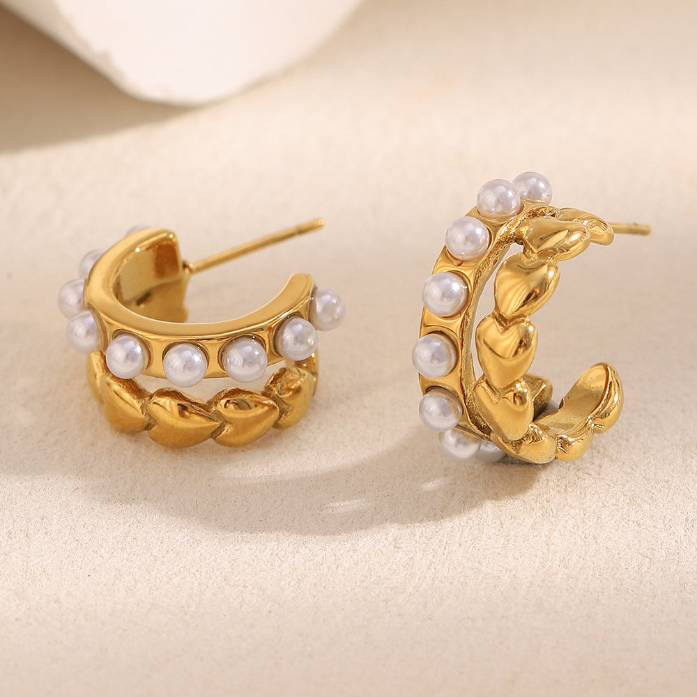 angled pair of gold plated heart and pearl open hoop earrings