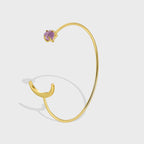 gold plated open cuff bracelet with crescent and purple stone ends