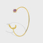 gold plated open cuff bracelet with crescent and purple stone ends