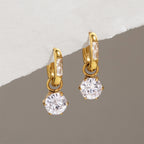Oval hoops with round zirconia drops hanging from a ledge