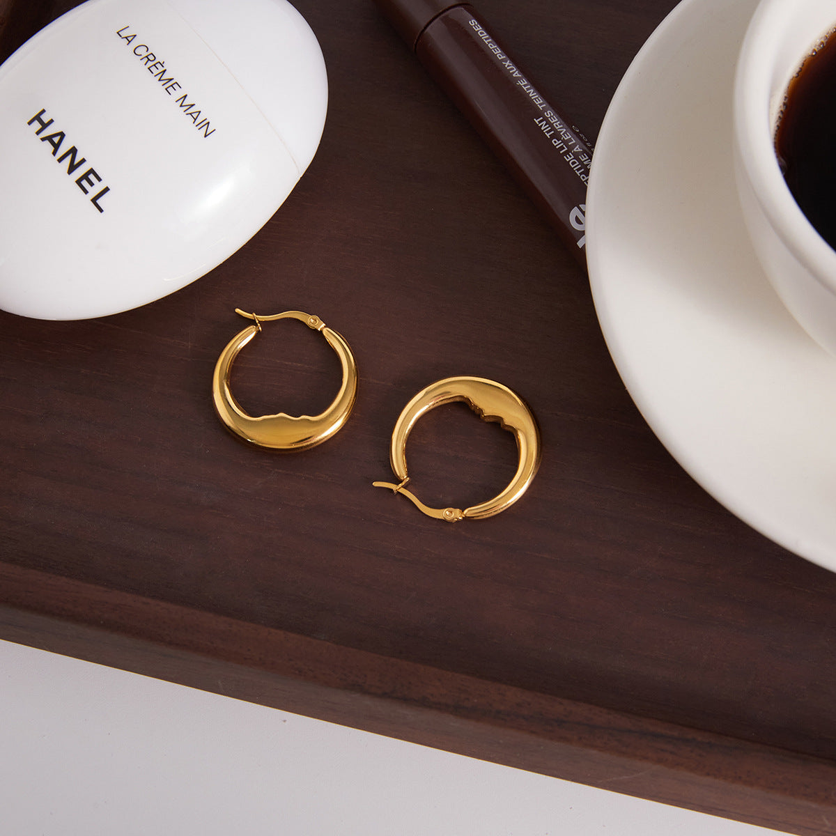 gold plated wavy oval hoops in a styled tabletop setting