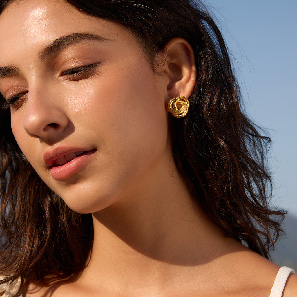 Rounded knot earrings styled on a model