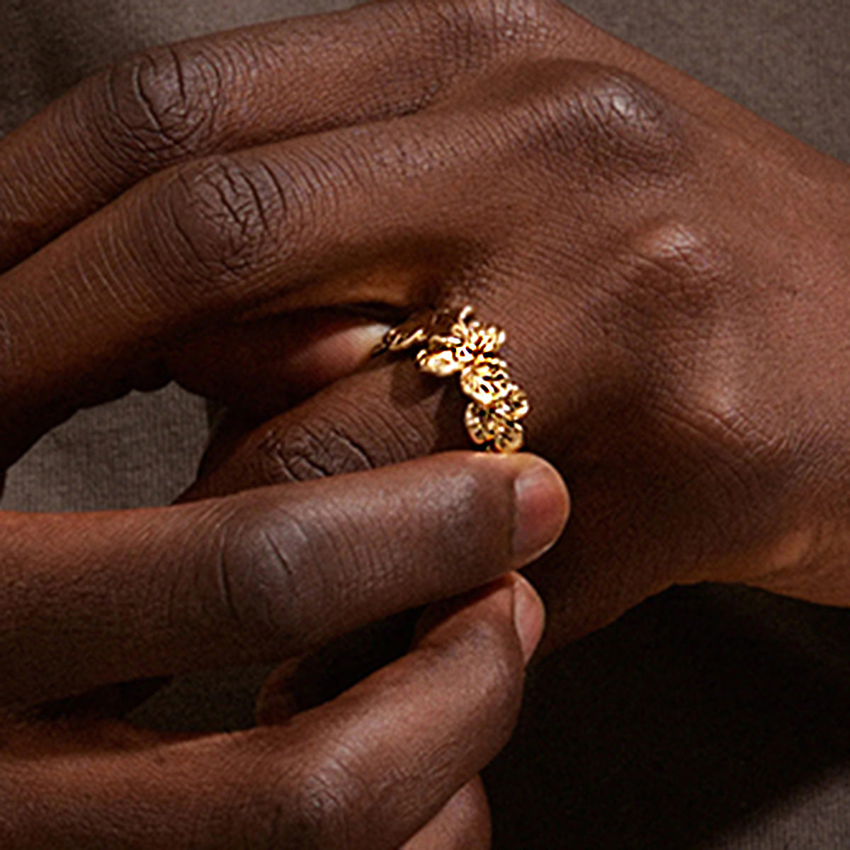 Sculpted flower band ring worn on a hand