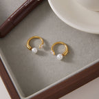 Pair of open hoop earrings on a neutral tray
