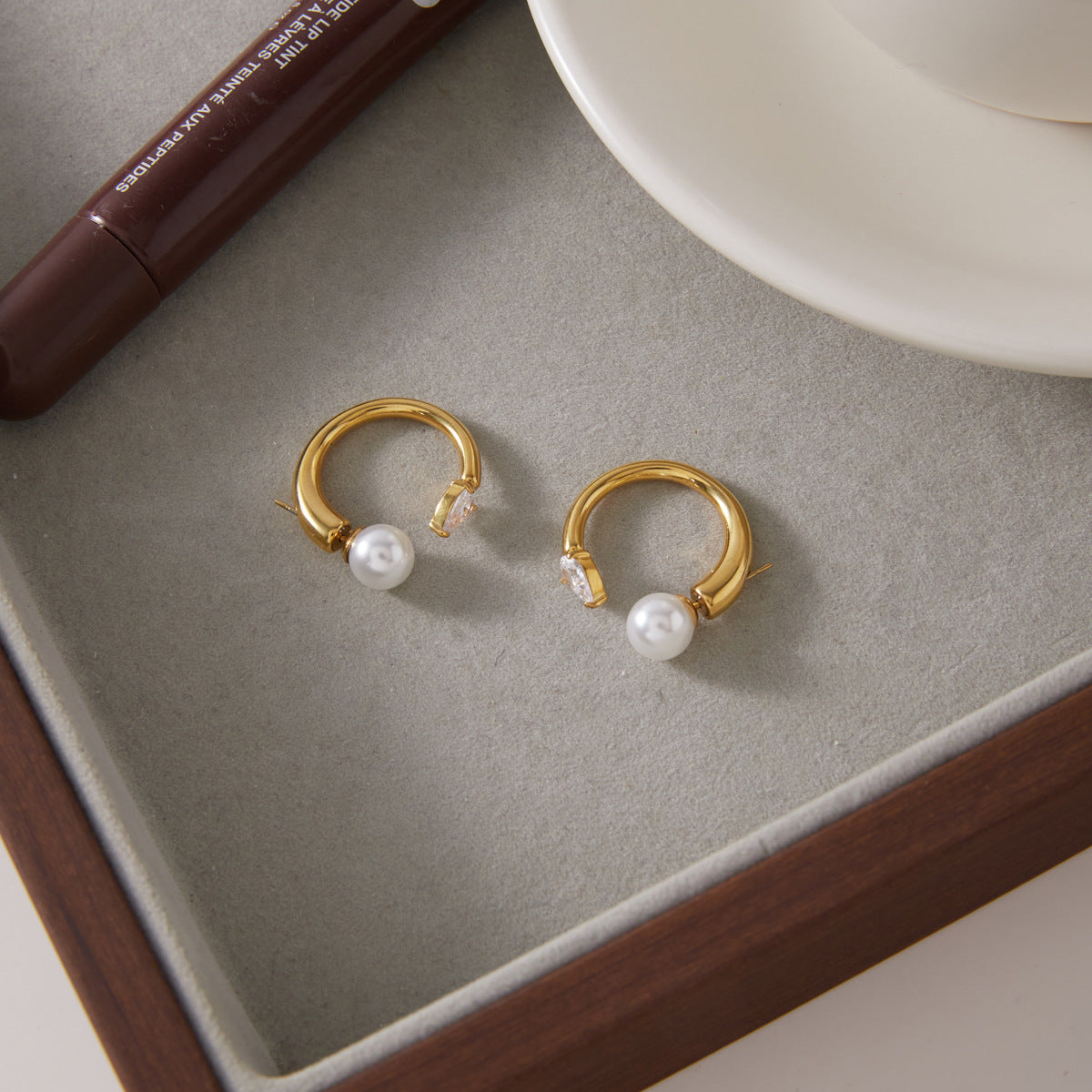 Pair of open hoop earrings on a neutral tray