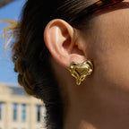 Gold-Tone Sculptural Heart Stainless Steel Stud Earrings shown on model