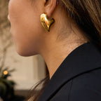 Gold-tone asymmetric sculptural heart stainless steel stud earrings worn view