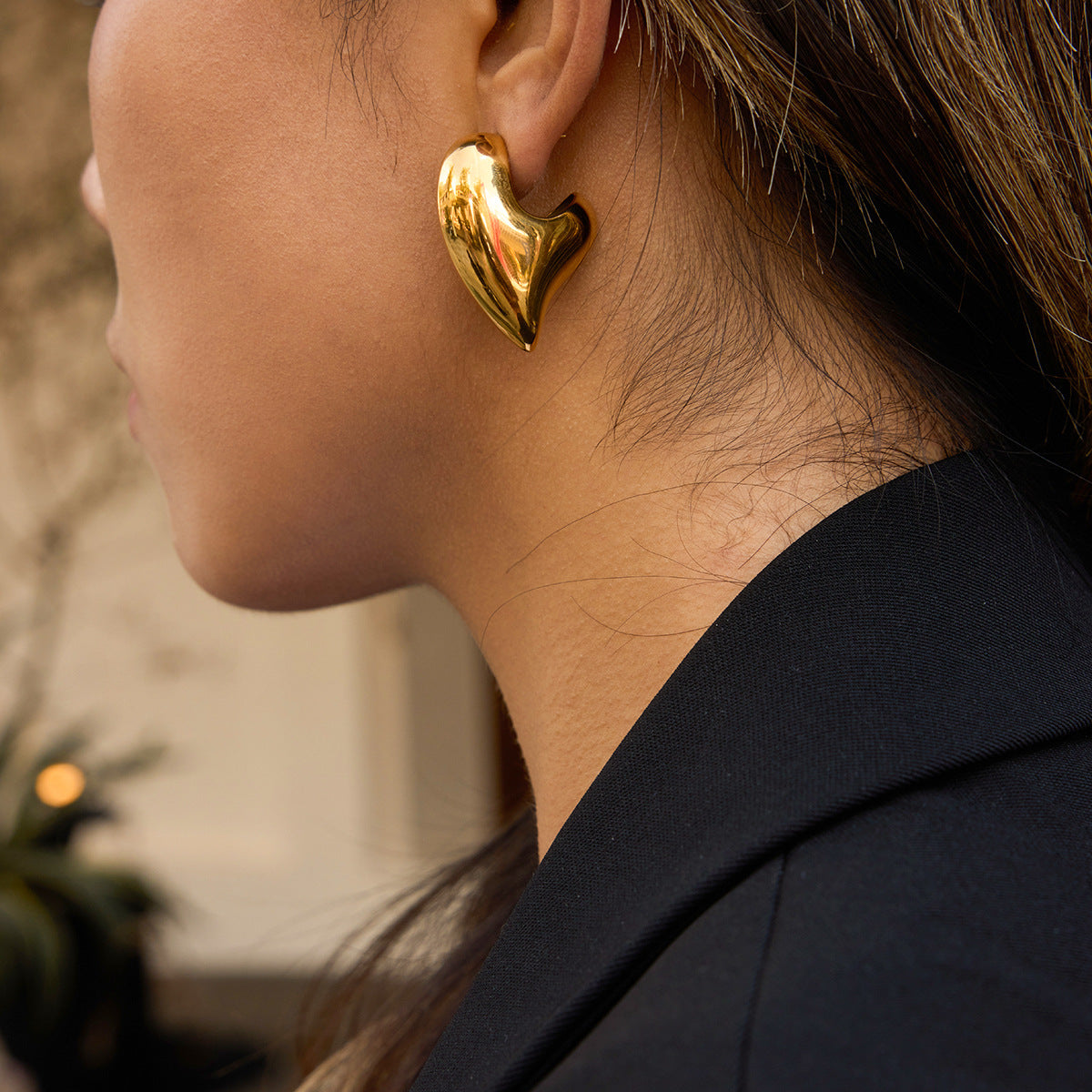 Gold-tone asymmetric sculptural heart stainless steel stud earrings worn view