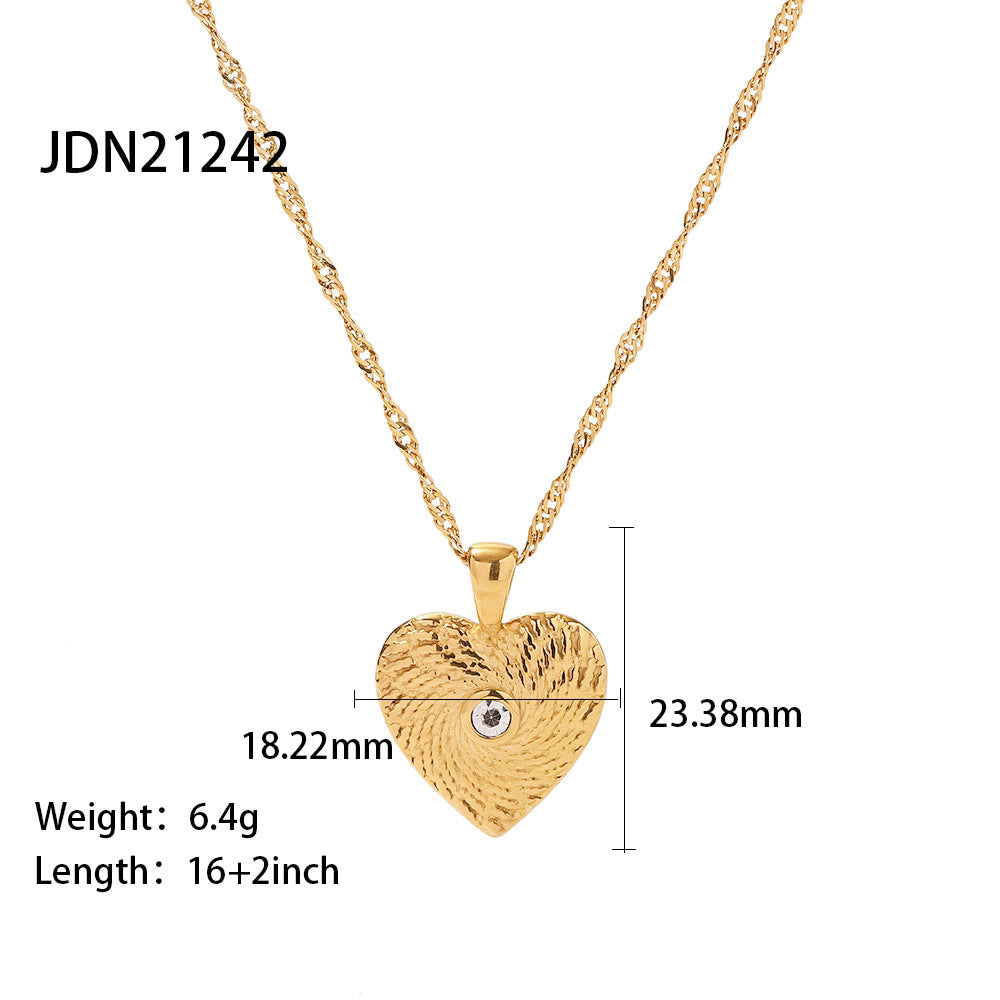 Textured heart pendant with a small clear center and size labels
