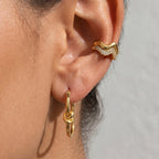 Gold tone knot hoop and wavy ear cuff worn together