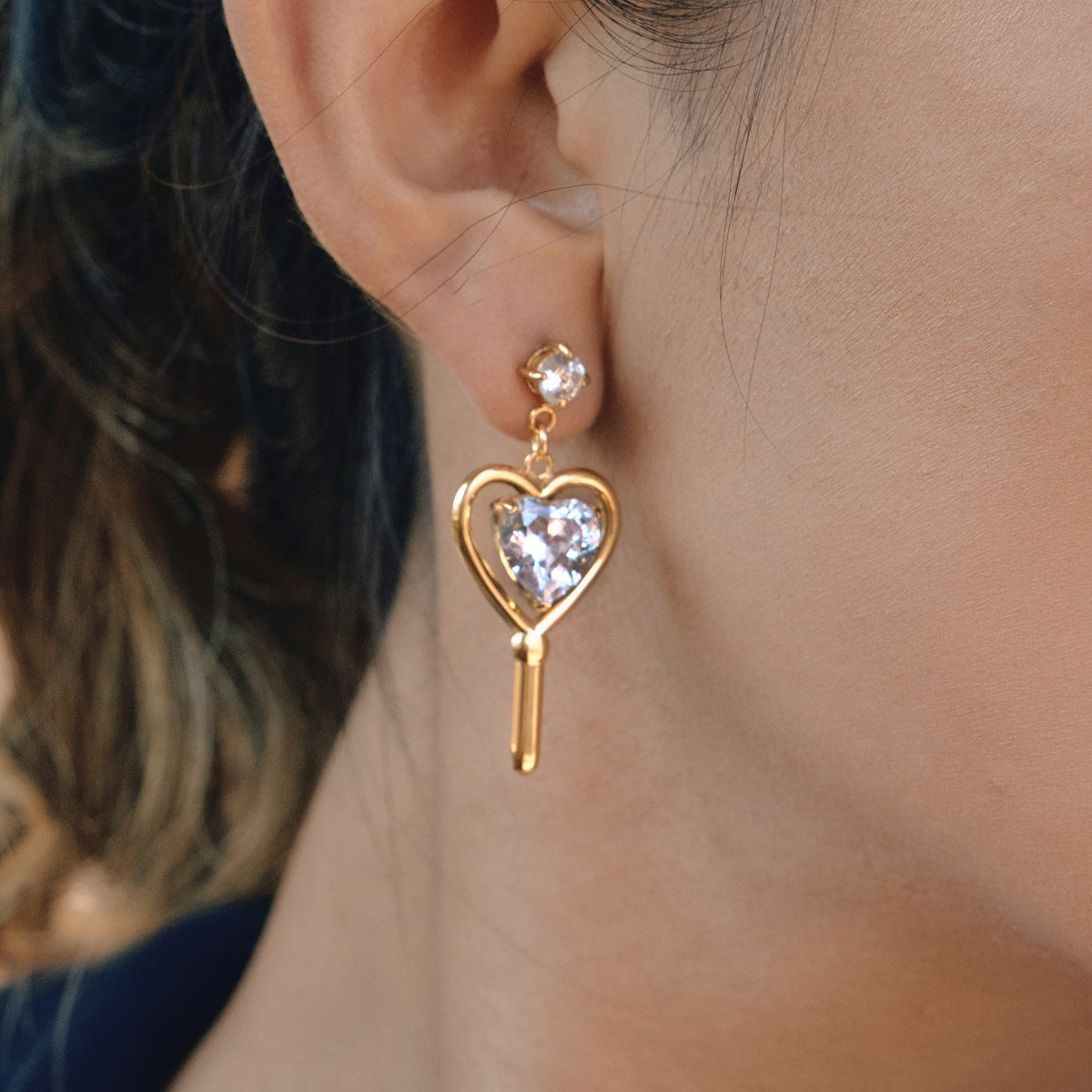 side view of mismatched gold plated heart drop earrings