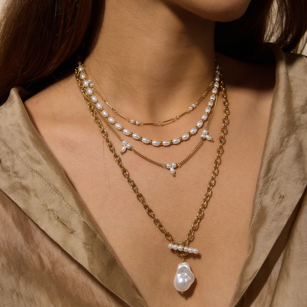 Four imitation pearl necklace designs layered on a bust