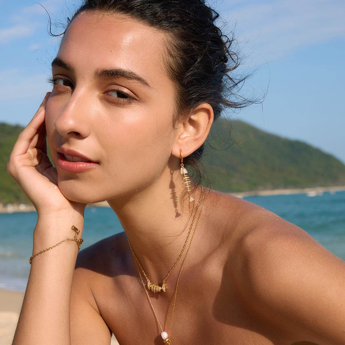 Long fish skeleton earrings styled on a model