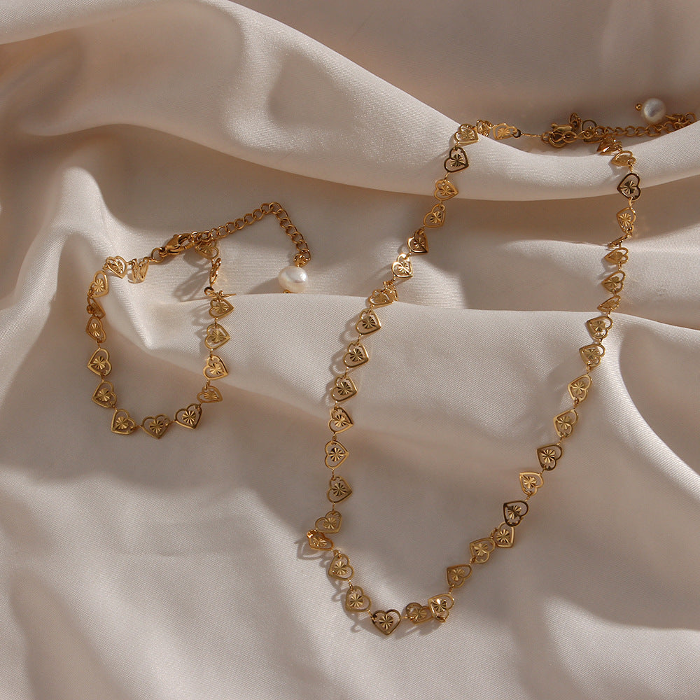 heart-link necklace and bracelet arranged together on satin