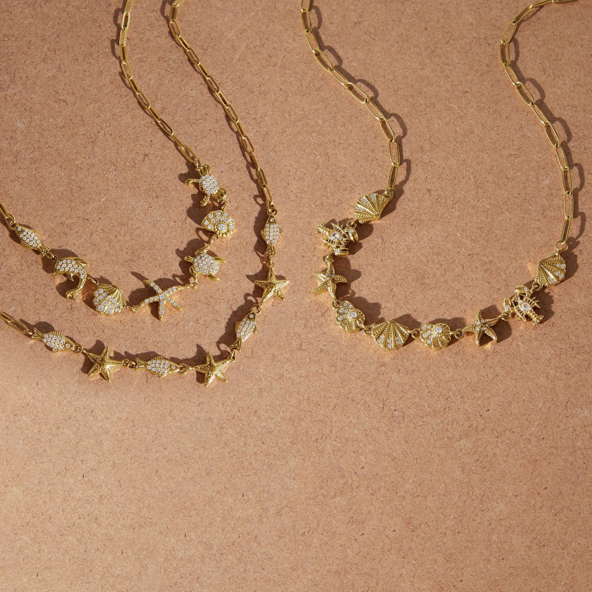 Three coastal necklaces with different marine charm arrangements