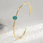 slim turquoise-color stone cuff standing on a textured surface