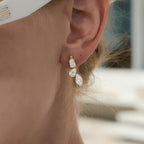 Rectangular and pear accents on a worn earring