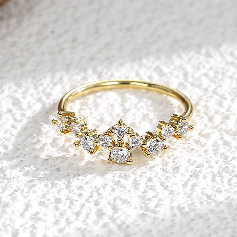 front view of staggered clear stones across a slim gold plated band