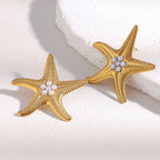 pair of textured gold plated starfish studs with pearl centers
