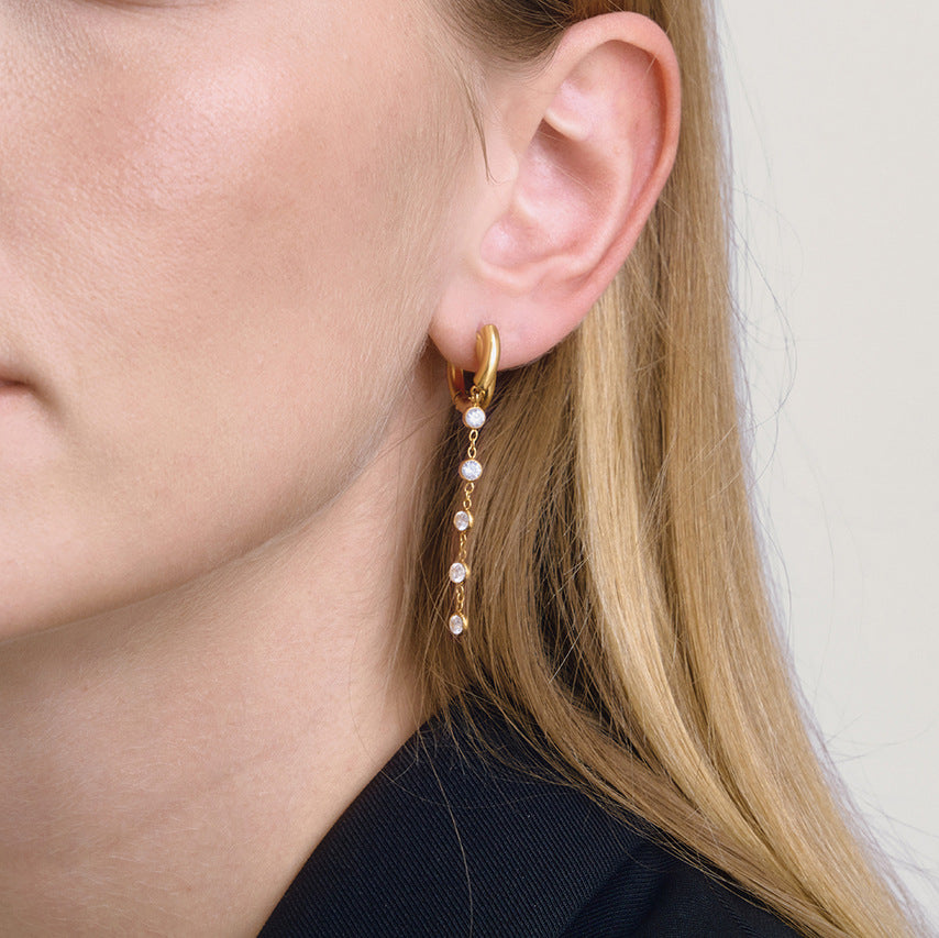 gold plated clear stone cascade huggie earrings worn in profile