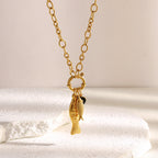gold plated stainless steel fish necklace arranged on satin