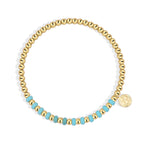 isolated gold plated bead bracelet with centered blue accent section