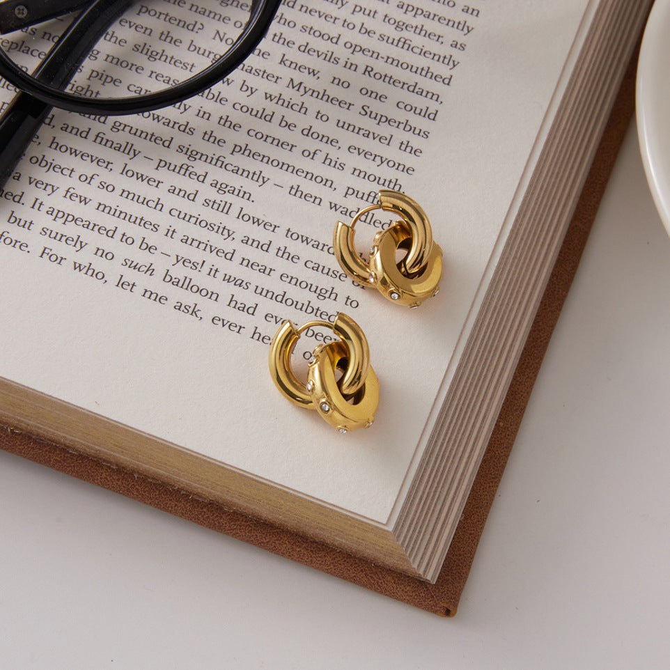 Polished oval drop earrings resting on a book