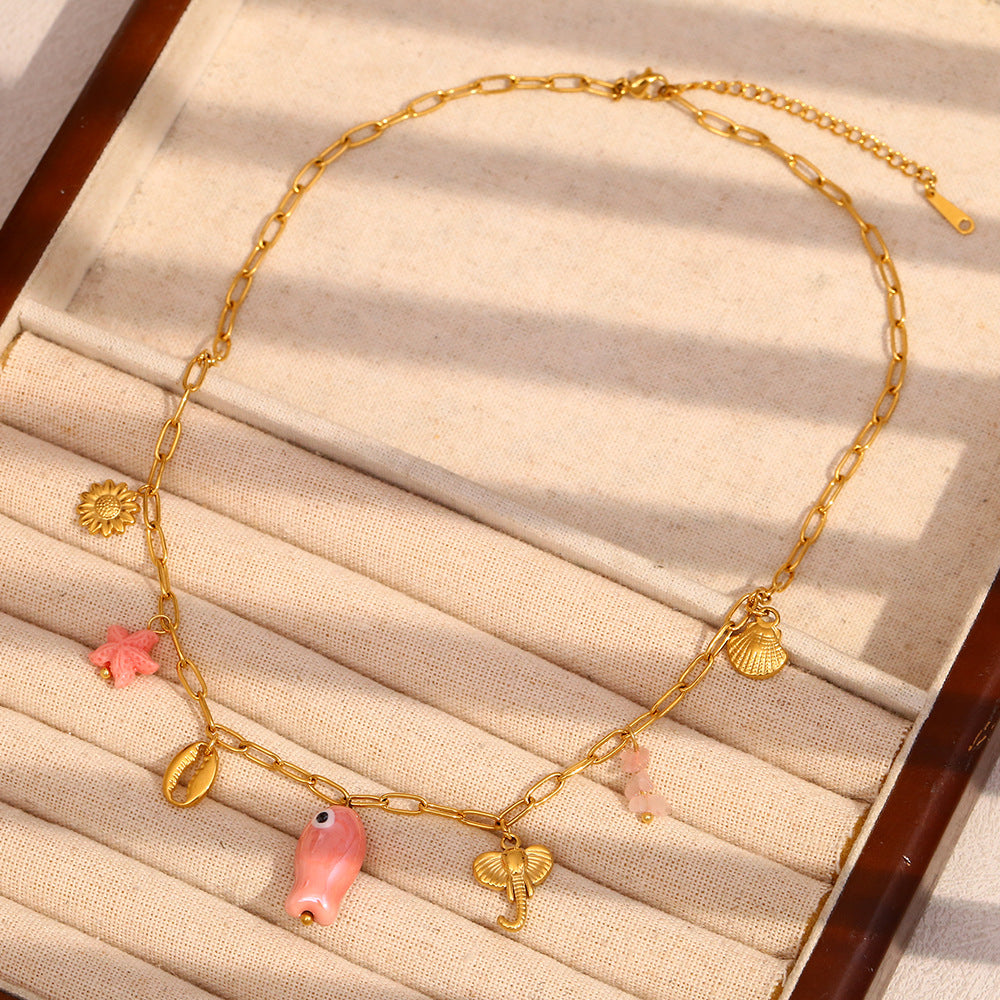 gold plated coastal necklace arranged with pink decorative accents