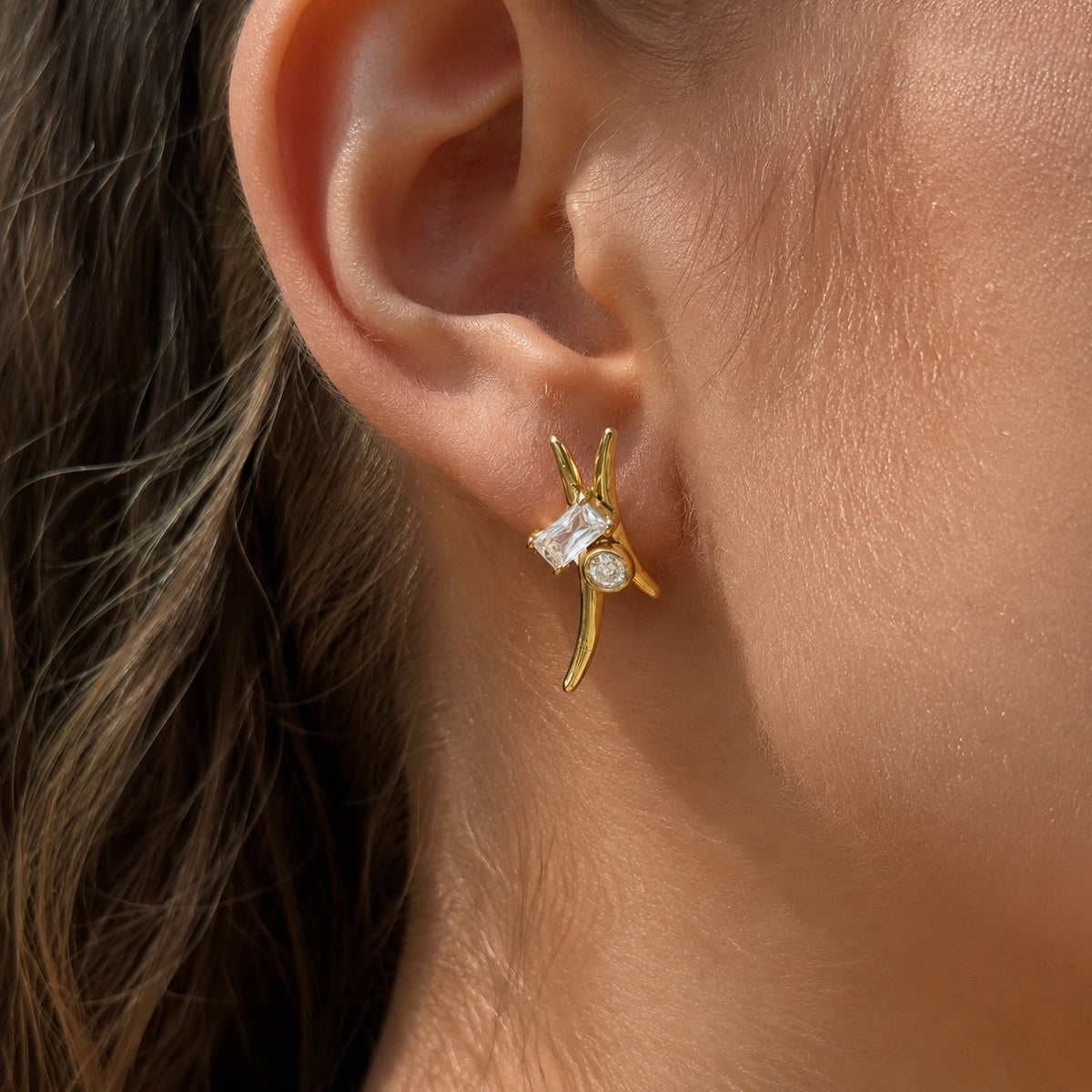 Curved zirconia stud earring worn on the lobe