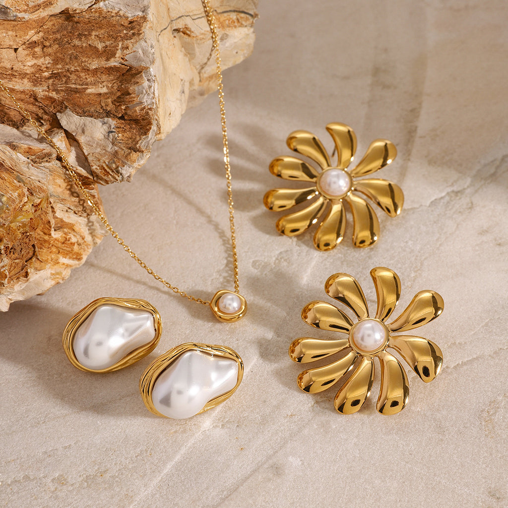 White center ring and necklace arranged on pale stone with separate floral earrings