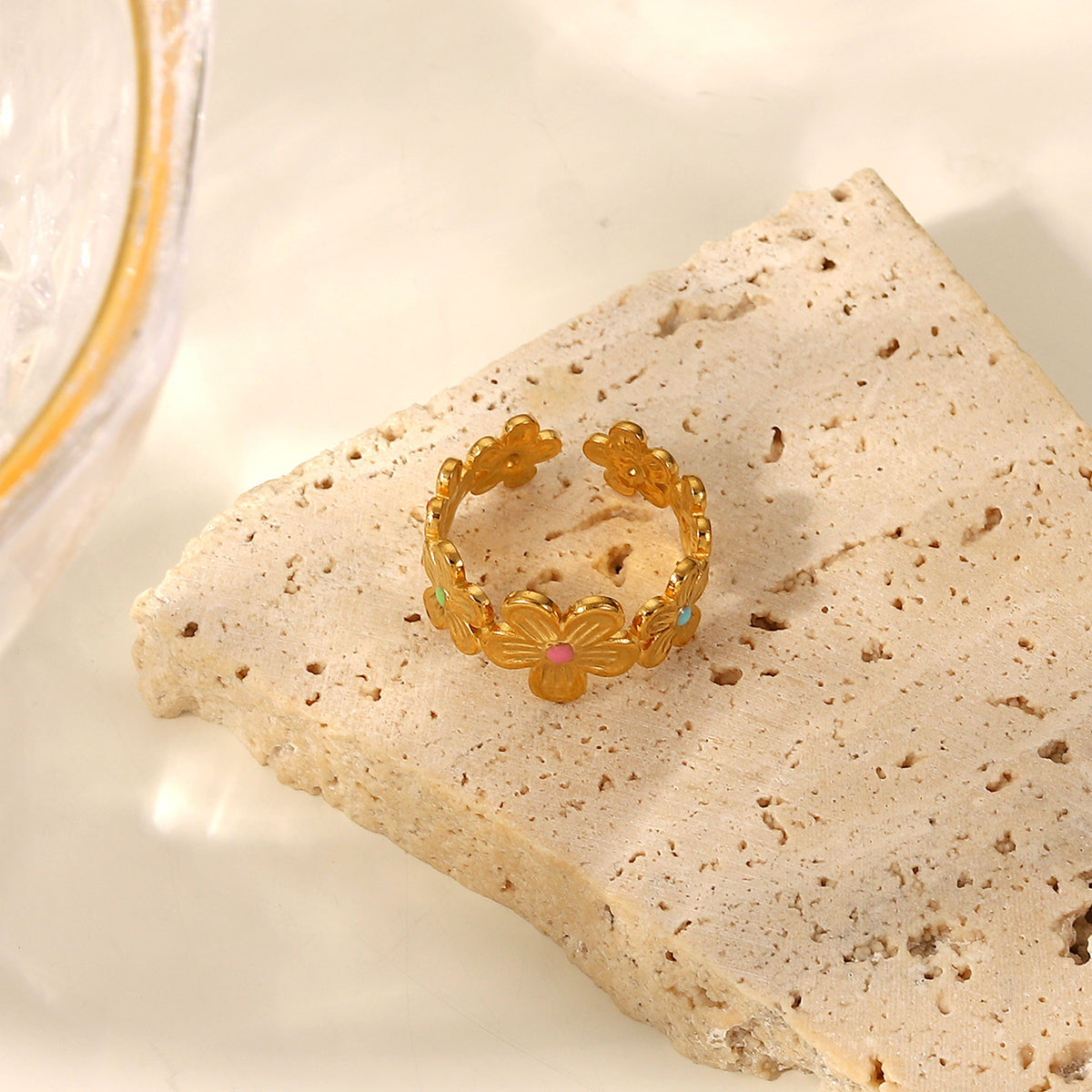 Floral garland ring with colored centers on a stone block