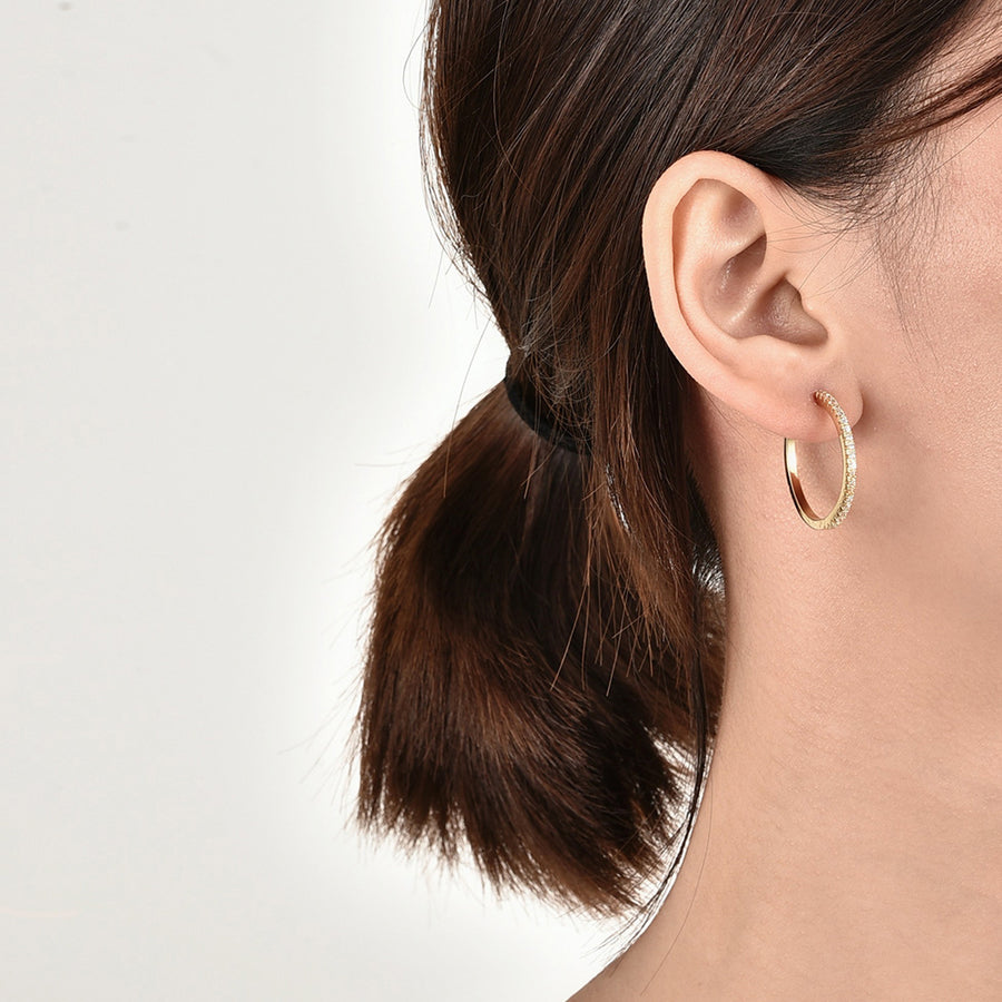 gold plated clear zirconia hoop earrings worn on the ear