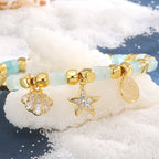 close view of clear-stone shell and starfish charms