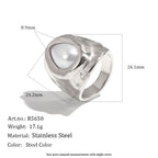 Silver tone ring showing hammered surface and white pearlescent setting