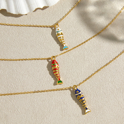 White blue and red fish pendants on a neutral surface