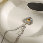 Radiating heart pendant and link chain on a white dish