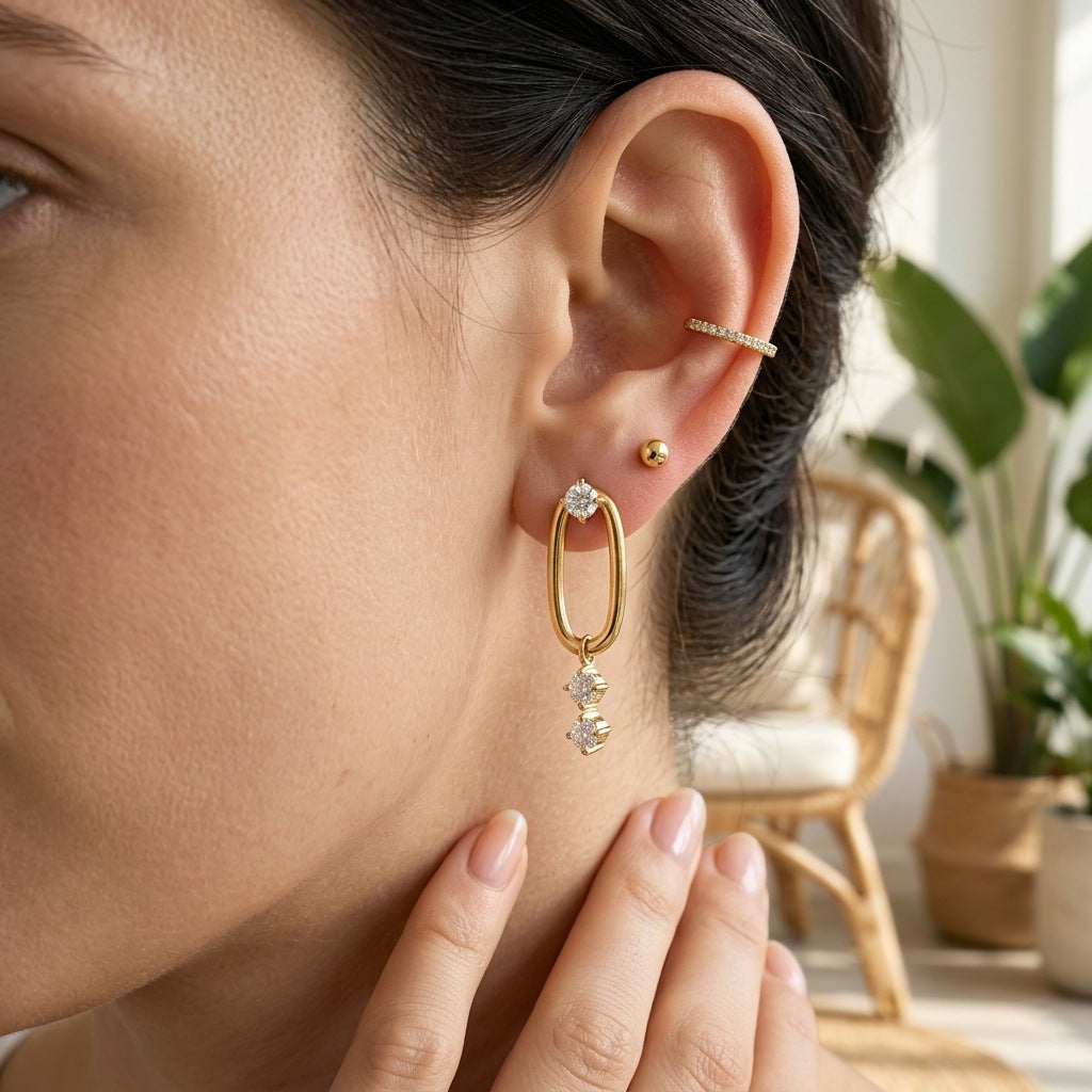 Gold tone oval drop earring shown from a second angle