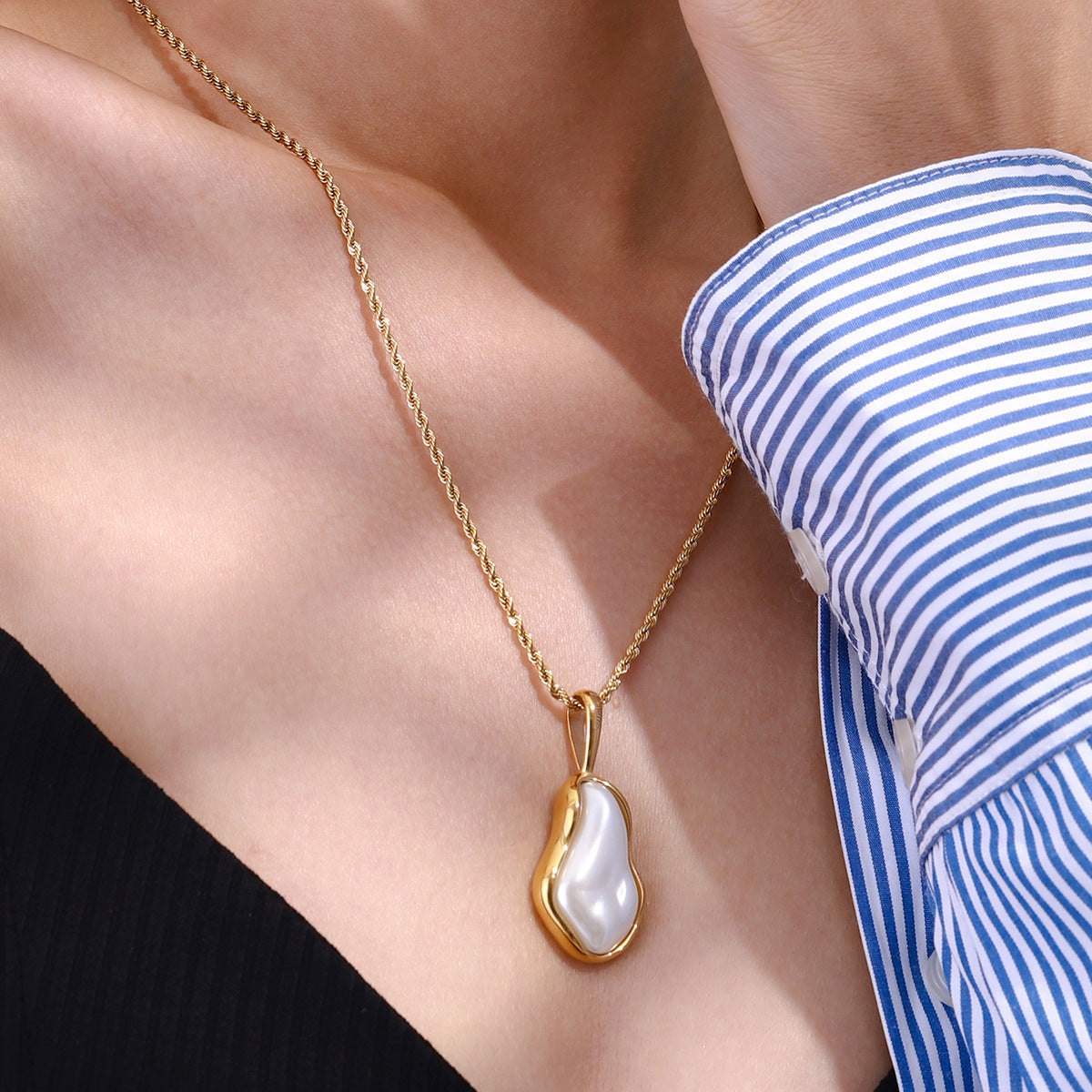 Single pendant necklace worn with a striped shirt